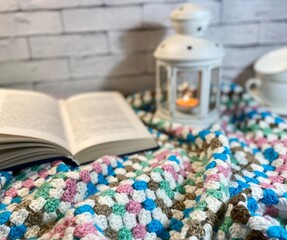 Cozy autumn or winter photo with crochet blanket, flashlight and blue headphones	
