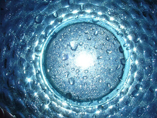 Abstract blue background with sunlight, glowing water drops and passing colors in white and...