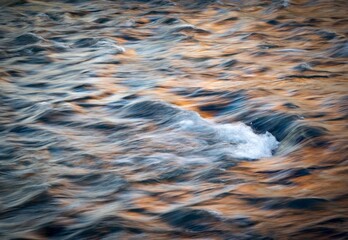 detail of a wave on an autumn colored river