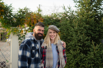 Happy young couple in love smiling and spending time together. Bearded man and beautiful blonde woman walking at fall autumnal park. Hipster couple enjoy autumn nature.