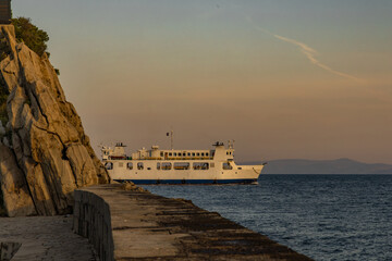 Obraz premium Sunrise ferry with passengers enters the port of Trpanj