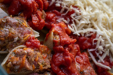 cooking pasta stuffed with minced meat in tomato and cheese, inclined horizon