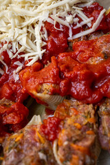 cooking pasta stuffed with minced meat in tomato and cheese, inclined horizon