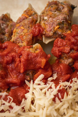 cooking pasta stuffed with minced meat in tomato and cheese, inclined horizon