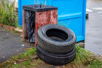 Obraz premium Discarded car tires. Pollution of the street with industrial waste. Environmental disaster
