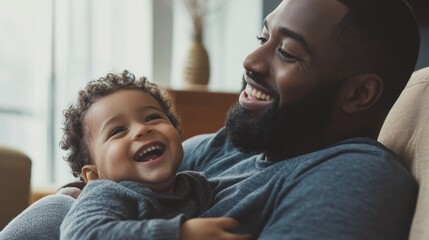 Obraz premium Happy father and son playing on the couch, sharing laughter and fun. Clean home environment, focusing on their loving connection.