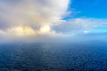 Ocean weather change from blue sky to low clouds and foggy conditions