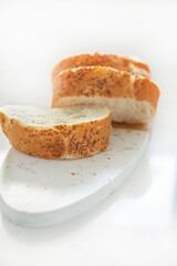 Sliced sesame bread on board isolated on white background, home baking concept
