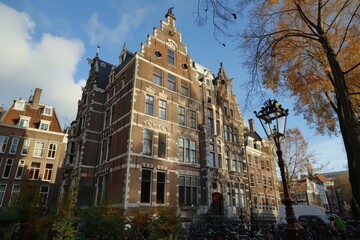 Traditional dutch architecture building standing tall on an amsterdam canal with a street lamp in the foreground