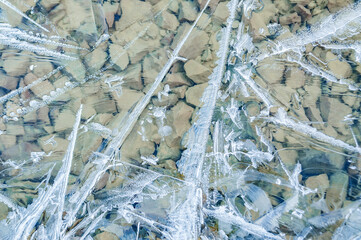 Full frame of frozen water surface in a river in the form of ice Abstract ice background. Blue background with cracks on the ice surface