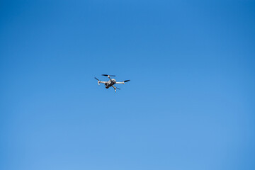 drone flies in the blue sky. overhead video recording equipment