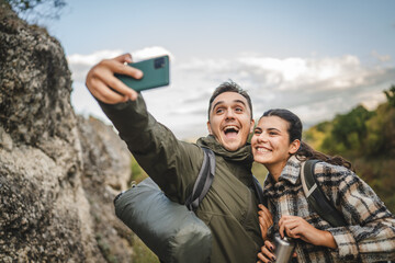 happy couple take a self portrait or video call on hiking