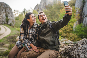 happy couple take a self portrait or video call on hiking