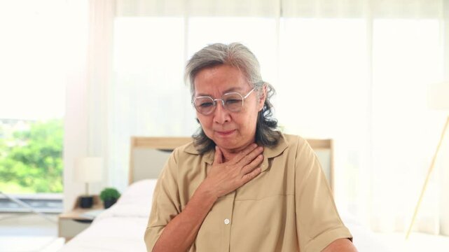 Elderly Asian woman with acid reflux sore throat after eating and lying down feeling burning in the esophagus irritation coughing shortness of breath and difficulty swallowing.