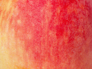 Red and yellow apple texture with water drops as background.