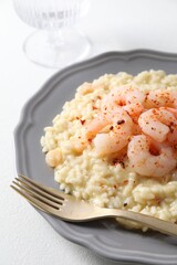 Delicious risotto with shrimps and cheese on white table, closeup