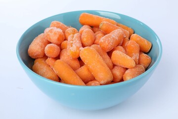 Frozen baby carrots in bowl isolated on white