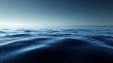 A serene and tranquil ocean with a calm, rippling surface extending to the horizon under a clear blue sky.