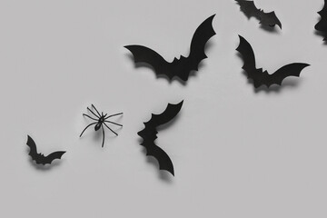 Paper bats and spider for Halloween party on grey background