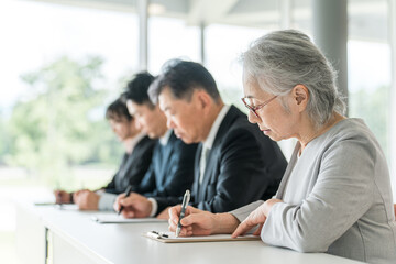 セミナー・講習会を受講するスーツ姿のビジネスマン男女
