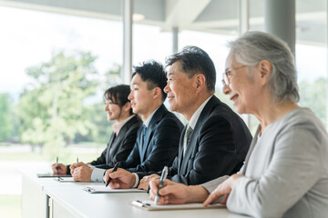 セミナー・講習会を受講するスーツ姿のビジネスマン男女
