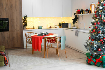 Interior of kitchen with counters, dining table and Christmas tree