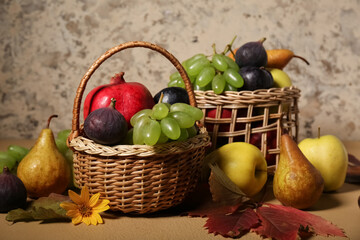 Wicker baskets with different fresh fruits on beige background