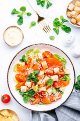 Foodie food salad with salmon, iceberg and lumb lettuce, croutons, parmesan cheese and caesar dressing. White background, top view