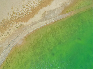 Turquoise waters of the lake meeting the desert in yadan landform park, Qinghai, China