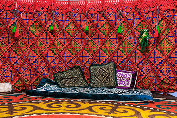 A colorful tent with red and green patterned wall, a place for meditation and prayer in a Kyrgyz...