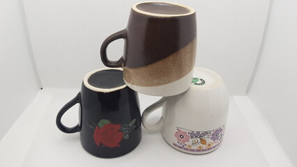 Three colored tea cups are lying on white background 