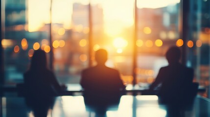 Silhouettes of Three People Sitting in Front of a Window with a Bright Sunset
