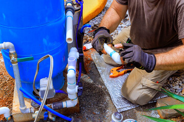 Plumber is assembling connection service between well water system in house.