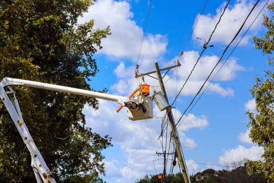 There is power outage following severe violent hurricane that damaged power line that has to be repaired by emergency workers