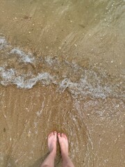 Fototapeta premium feet on the beach,with sea water and sands,This photo was taken on the beach in A Coruña, Spain