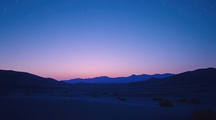 The desert sky transitioning from night to dawn, with stars fading as the sky fills with soft blues and purples over the dunes