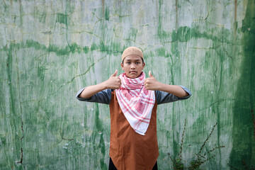 Wearing a peci and turban, a Muslim man gives a thumbs-up as a sign of agreement