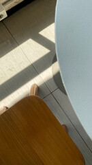 box-shaped wooden chairs with sunlight reflecting off the floor and shadow 
