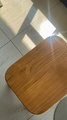 box-shaped wooden chairs with sunlight reflecting off the floor and shadow 
