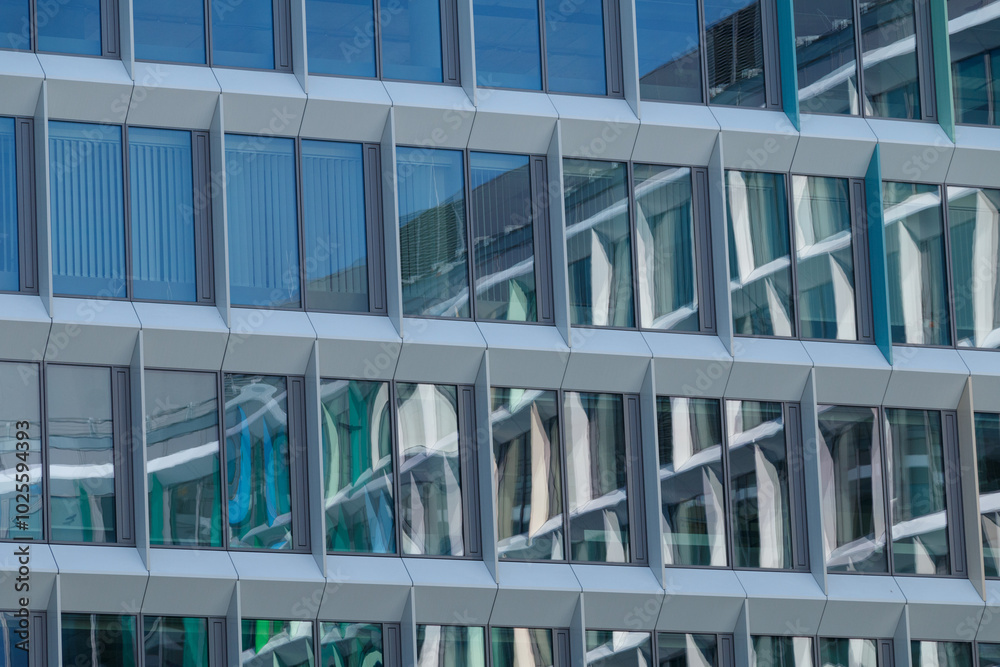 Wall mural a close-up view of a modern building facade featuring a geometric pattern of blue and white panels w