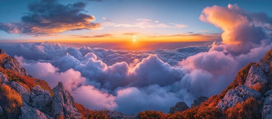 Fototapeta premium Dramatic sunrise over a sea of clouds with a view from a mountain peak.