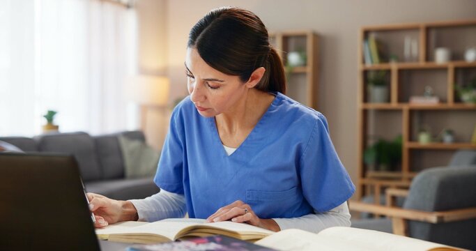 Nurse, woman and studying with books at desk for medical research, information and knowledge. Home, healthcare and reading with laptop in living room for diagnosis reference, guide and treatment plan