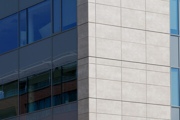Obraz premium A modern building facade featuring a geometric pattern of blue panels with rectangular windows. 