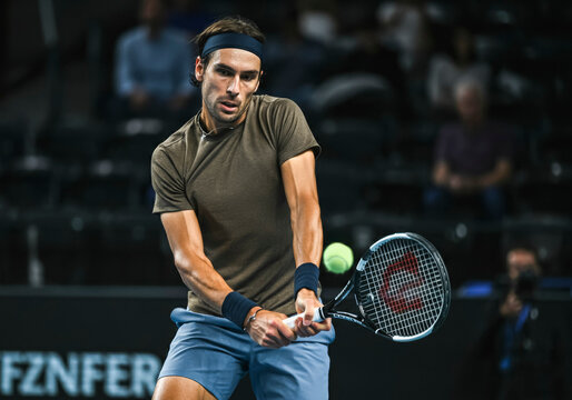 Intense tennis match: player performing backhand swing
