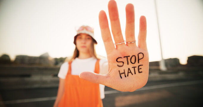 Hands, stop hate and equality for person with writing, sign and protest for racism, peace and inclusion. Woman, palm and outdoor for activism, accountability and human rights on bridge in Germany