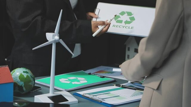 Business people having consultation about wind energy at company office. Business team discussing about windmill and alternative green enery. Net zero and carbon neutral concept