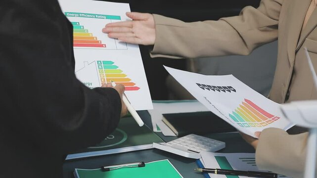 Business people having consultation about wind energy at company office. Business team discussing about windmill and alternative green enery. Net zero and carbon neutral concept