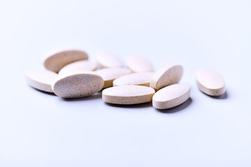 Ashwagandha (Withania somnifera) tablets. Concept for a healthy dietary supplementation. Bright paper background. Close up. Copy space.	