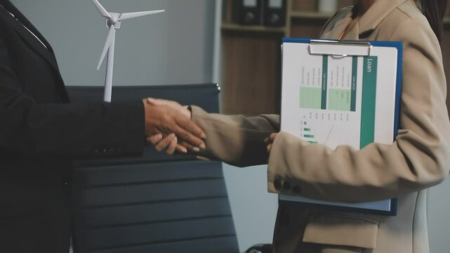 Business people having consultation about wind energy at company office. Business team discussing about windmill and alternative green enery. Net zero and carbon neutral concept