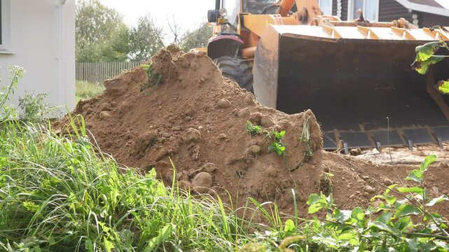 bulldozer works on a construction site with sand to level the ground for the foundation